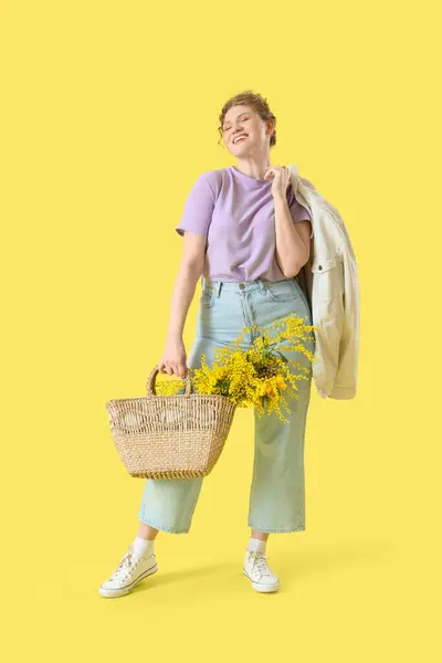 Glückliche Junge Frau Mit Korbtasche Mit Blumenstrauß Auf Gelbem Hintergrund — Stockfoto