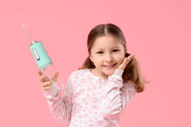 Pembe arka planda ağız sulandırıcısı olan mutlu küçük kız.