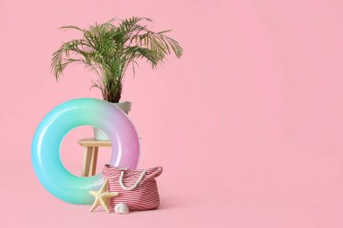 Şişirilebilir halka, pembe arka planda bitki ve torba