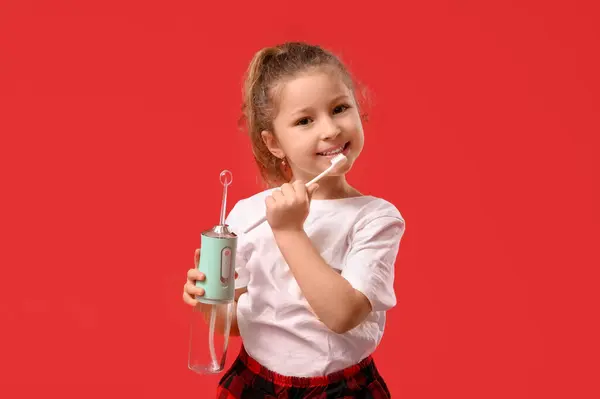 Menina Bonito Com Irrigador Oral Escova Dentes Fundo Vermelho — Fotografia de Stock