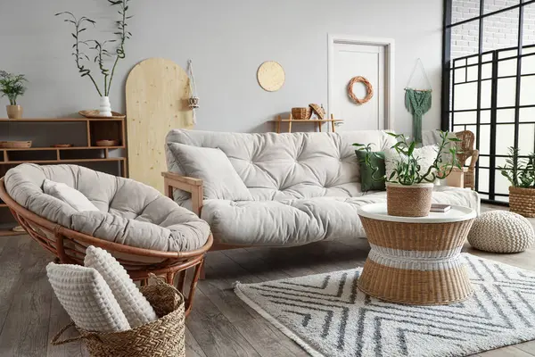 Interior of light living room with bamboo stems on coffee table and white sofa