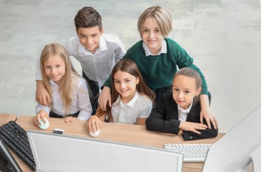 Okulun bilgisayar laboratuvarında okuyan küçük çocuklar.