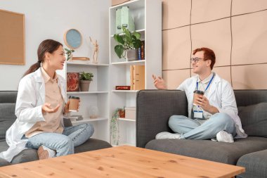 Genç doktorlar hastane salonunda kahve içiyorlar.