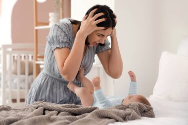 Doğum sonrası depresyondan muzdarip bebeğiyle öfkeli genç bir kadın.