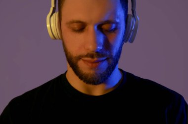 Karanlık arka planda modern kulaklıklı genç adam.