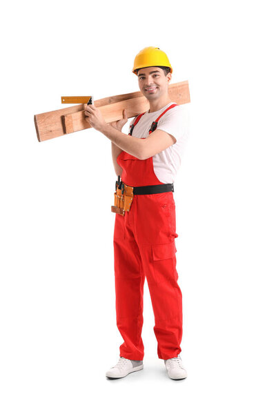 Young carpenter with wooden planks and ruler on white background