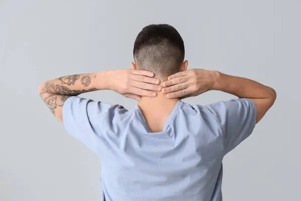 Junger Mann Mit Nackenschmerzen Auf Hellem Hintergrund Rückansicht — Stockfoto