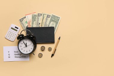 Bej arka planda çalar saat, para ve hesap makinesi olan kompozisyon. Zaman yönetimi konsepti. Üst görünüm