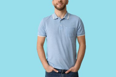 Mavi arka planda şık polo tişörtlü adam.