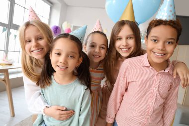 Doğum günü partisinde kucaklaşan sevimli küçük çocuklar.