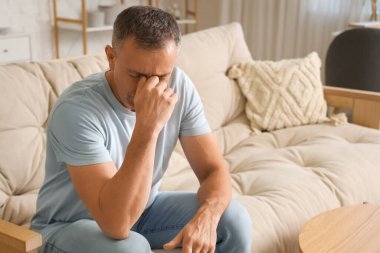 Evde migrenden muzdarip olgun bir adam.