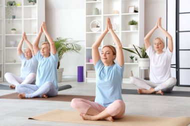 Spor salonunda yoga yapan bir grup olgun kadın.