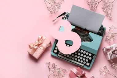 Daktilo, hediye kutuları, çiçekler ve pembe arka planda sekiz numara şeklinde kartpostal içeren şenlikli kompozisyon