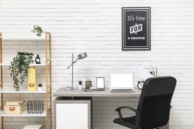 Çalışma yeri, dizüstü bilgisayarı ve koltuğu olan beyaz modern ofisin şık iç tasarımı