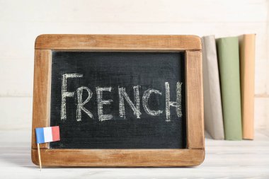 Kelime FRENCH ve hafif ahşap arkaplan kitapları ile tebeşir tahtası