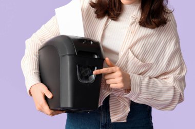 Leylak arka planında kağıt öğütücüsü olan sekreter