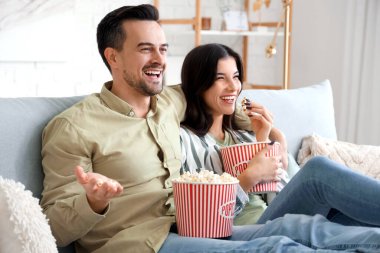 mutlu çift evde tv izlerken patlamış mısır ile