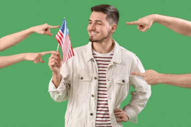 People pointing at young man with USA flag on green background. Accusation concept clipart