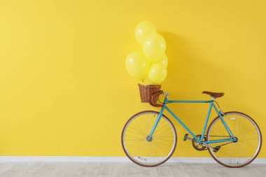 Sarı arka planda balonları olan bisiklet.