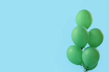 Mavi arkaplanda yeşil yüzen balonlar
