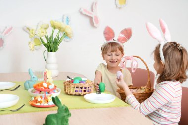 Paskalya yumurtalı şirin çocuklar evde yemek yiyor.