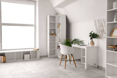 Masası ve raf ünitesi olan aydınlık oturma odasının içinde.