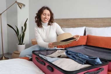 Otel odasında bavulu boşaltan kadın turist.