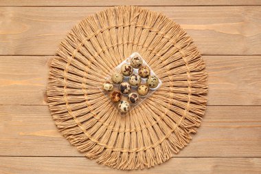 Tahta arka planda taze bıldırcın yumurtaları olan tutucu.