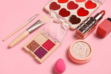 Pembe arka planda kozmetik ürünler seti