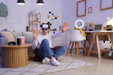 Evde VR gözlük kullanan bir erkek öğrenci.