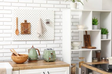 Tahta ve mutfak gereçleri olan şık bir mutfak.