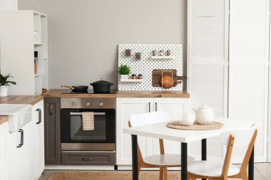 Tahta ve modern yemek masası olan şık bir mutfak.