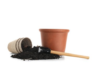Beyaz arka planda tencere, tırmık ve toprak