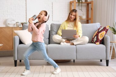 Çalışan genç kadın, gürültücü küçük kızının evde şarkı söylemesinden dolayı stresli.