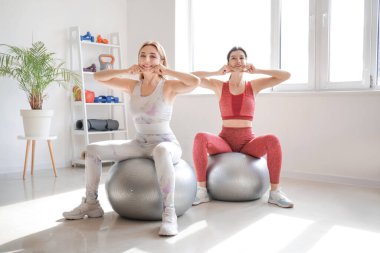 Fizyoterapistli güzel, mutlu, olgun bir kadın rehabilitasyon merkezinde vücut geliştirme egzersizi yapıyor.