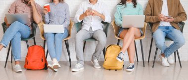 Modern cihazları olan öğrenciler çevrimiçi olarak kapalı alanda çalışıyorlar.
