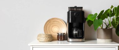 Modern kahve makinesi ve fasulyeler masada.