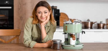 Mutfakta kahve makinesi olan genç bir kadın.