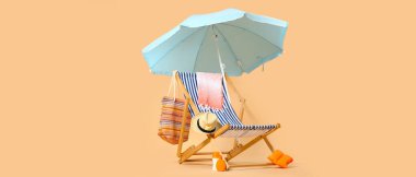 Güverte sandalyesi, şemsiye ve bej arka planda plaj aksesuarları.