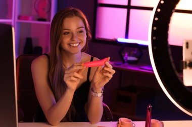 Female blogger with vibrator conducting sex education online at home