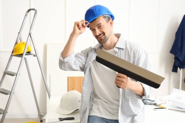 Macun bıçağıyla odada çalışan erkek dekoratör.