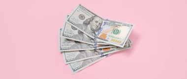 Pembe arka planda dolar banknotları