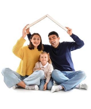 Çatı şeklinde mukavvalı olan mutlu bir aile beyaz arka plandaki yeni evlerini düşlüyor.