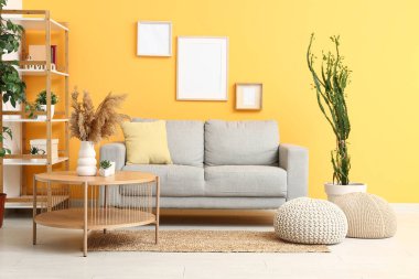 İçinde sehpa, kanepe ve puf olan modern oturma odası.