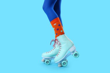 Mavi arka planda patenli kadın bacakları