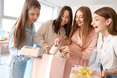 Bebek partisinde arkadaşlarından hediye alan hamile bir kadın.