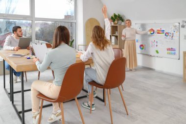 Olgun resim öğretmeni okulda öğrencilere ders veriyor.