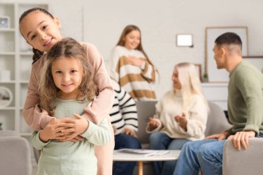 Evde kucaklaşan şirin küçük kız kardeşler.