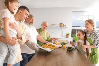 Mutfakta fırında patates olan büyük bir aile.