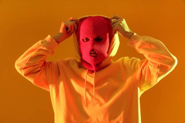 Sarı arka planda kar maskeli yakışıklı bir genç.